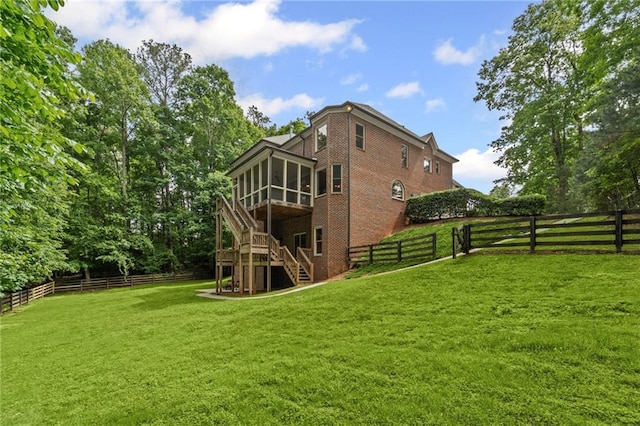 rear view of property featuring a sunroom, stairway, and brick siding