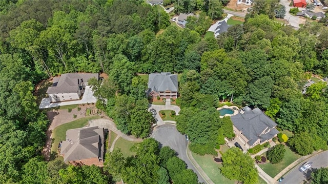 aerial overview of property's location featuring nearby suburban area and a heavily wooded area