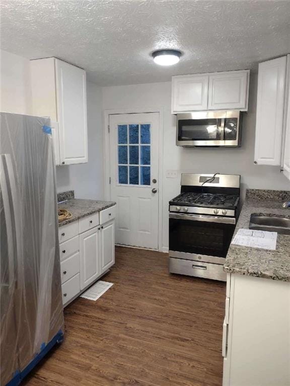 3543 S Cobb Dr S, Smyrna, GA 30080 - kitchen featuring dark wood-style floors, white cabinets, a sink, and stainless steel appliances