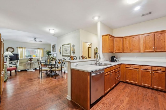 119 Holiday Rd, Unit Buford, GA 30518 - kitchen featuring stainless steel dishwasher, wood finished floors, light countertops, brown cabinetry, and a peninsula