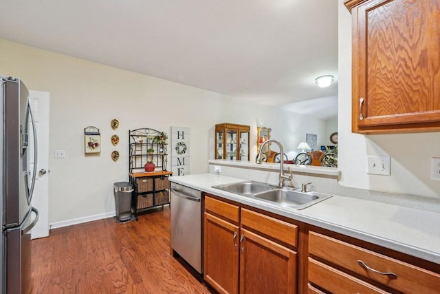 119 Holiday Rd, Unit Buford, GA 30518 - kitchen featuring appliances with stainless steel finishes, light countertops, dark wood finished floors, brown cabinetry, and a peninsula