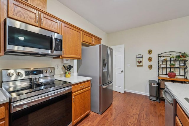 119 Holiday Rd, Unit Buford, GA 30518 - kitchen with appliances with stainless steel finishes, wood finished floors, brown cabinets, and light countertops