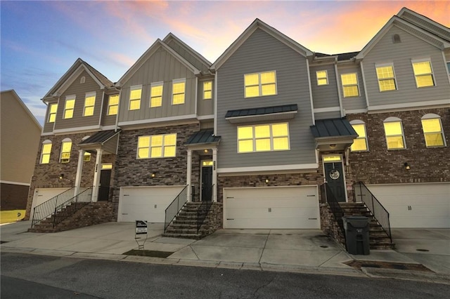 4262 Buford Valley Way, Buford, GA 30518 - townhome / multi-family property featuring concrete driveway, an attached garage, a standing seam roof, and stone siding