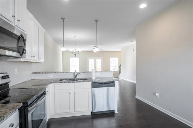 kitchen featuring pendant lighting, stainless steel appliances, sink, and white cabinets