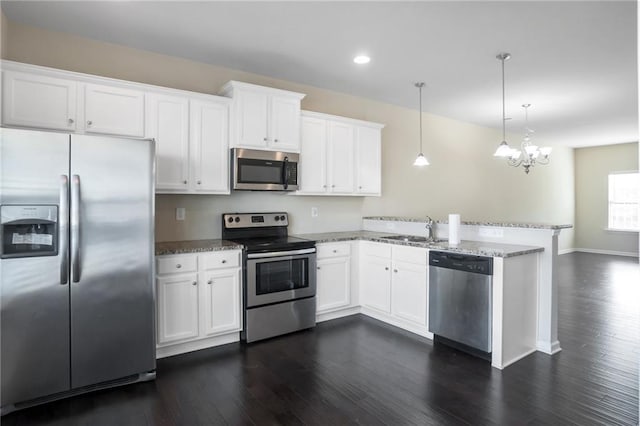 kitchen featuring pendant lighting, white cabinetry, sink, kitchen peninsula, and stainless steel appliances