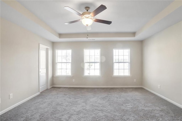 unfurnished room with ceiling fan, a raised ceiling, and carpet floors