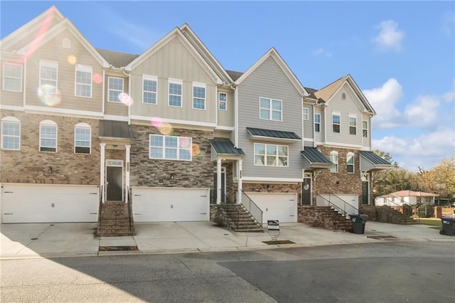 4262 Buford Valley Way, Buford, GA 30518 - townhome / multi-family property with board and batten siding, an attached garage, driveway, and stone siding