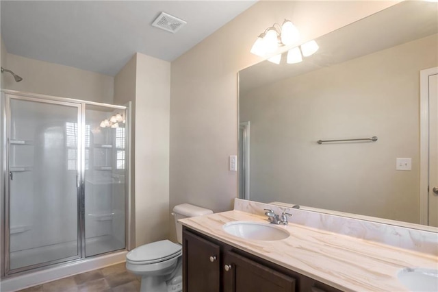 bathroom featuring a shower with door, vanity, and toilet