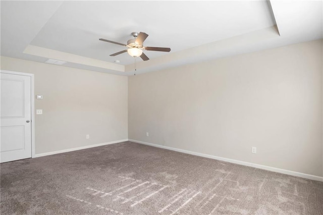 unfurnished room featuring carpet, ceiling fan, and a tray ceiling