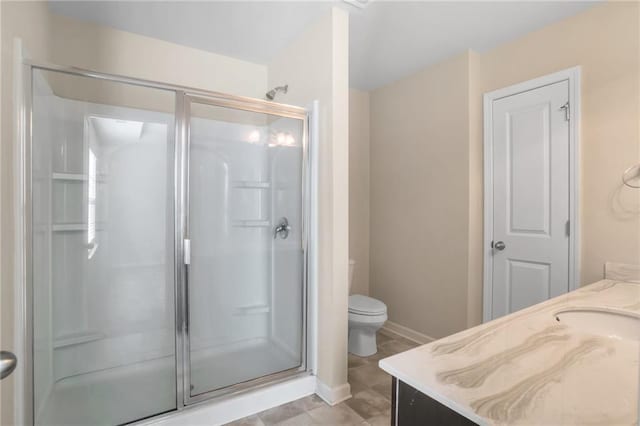 bathroom featuring vanity, toilet, and an enclosed shower