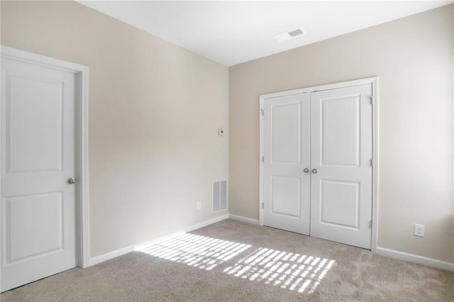 unfurnished bedroom featuring light colored carpet and a closet