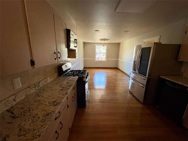 2807 Mcclave Dr, Doraville, GA 30340 - kitchen with appliances with stainless steel finishes, wood finished floors, baseboards, and light stone countertops