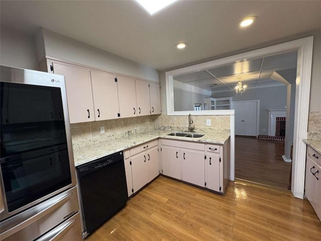 2807 Mcclave Dr, Doraville, GA 30340 - kitchen featuring dishwasher, light wood-type flooring, a sink, decorative backsplash, and white cabinets