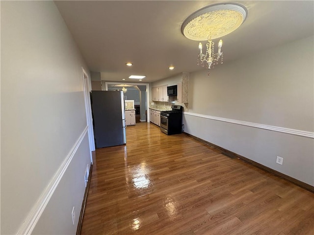 2807 Mcclave Dr, Doraville, GA 30340 - unfurnished living room featuring a chandelier, recessed lighting, and wood finished floors