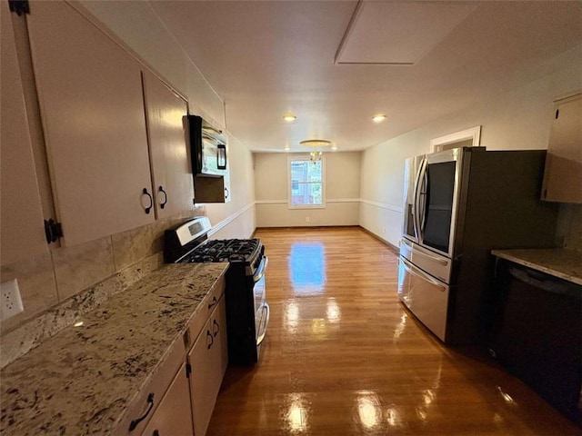 2807 Mcclave Dr, Doraville, GA 30340 - kitchen with appliances with stainless steel finishes, light wood-style floors, light stone counters, baseboards, and tasteful backsplash