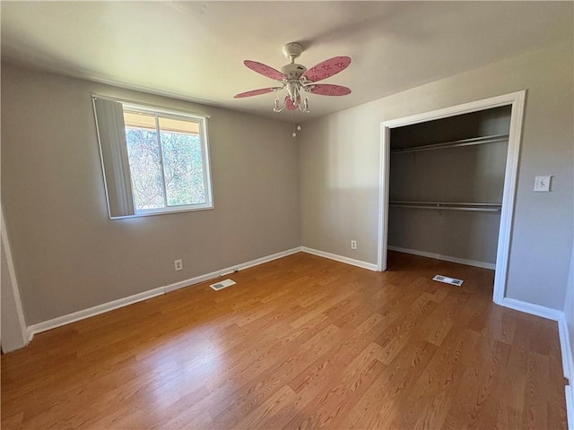 2807 Mcclave Dr, Doraville, GA 30340 - unfurnished bedroom featuring baseboards, a closet, wood finished floors, a ceiling fan, and a walk in closet