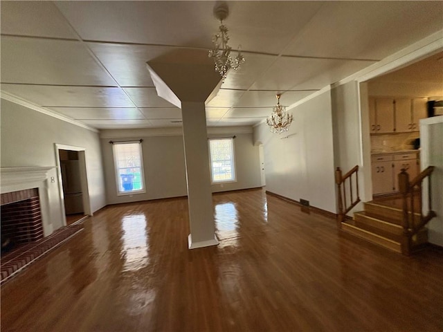 2807 Mcclave Dr, Doraville, GA 30340 - unfurnished living room with a chandelier, a fireplace, wood finished floors, crown molding, and stairs