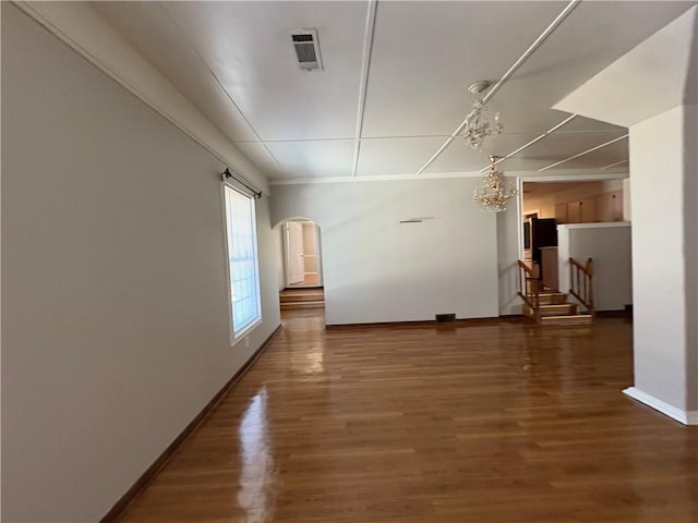 2807 Mcclave Dr, Doraville, GA 30340 - empty room with a chandelier, arched walkways, baseboards, and wood finished floors