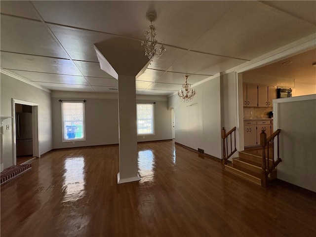 2807 Mcclave Dr, Doraville, GA 30340 - unfurnished living room with a chandelier, wood finished floors, crown molding, baseboards, and stairs
