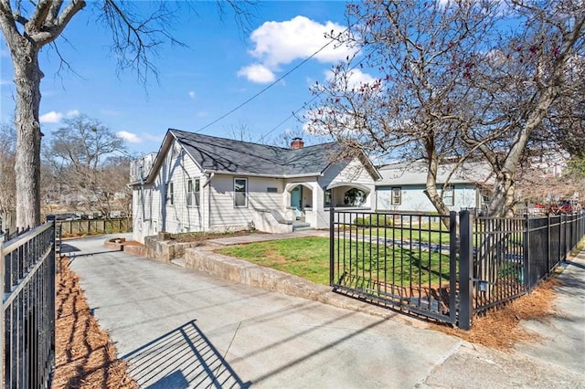 view of front facade with a front yard, a gate, a fenced front yard, and a chimney