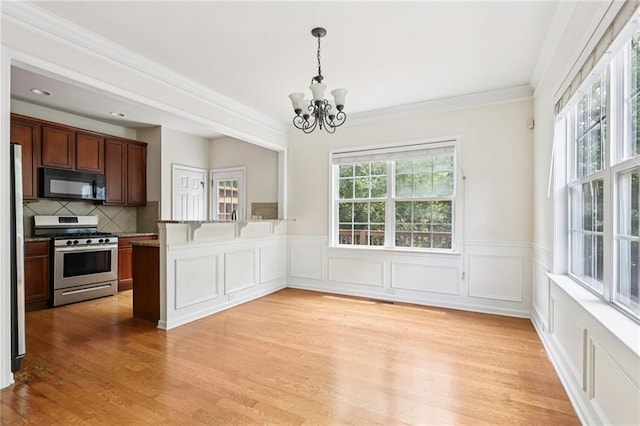 626 Pecan Knoll Dr Unit 13, Marietta, GA 30008 - unfurnished dining area with a chandelier, light wood finished floors, crown molding, wainscoting, and a decorative wall