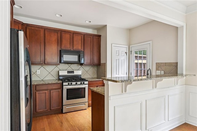 626 Pecan Knoll Dr Unit 13, Marietta, GA 30008 - kitchen featuring stainless steel appliances, a peninsula, light stone counters, decorative backsplash, and a kitchen bar