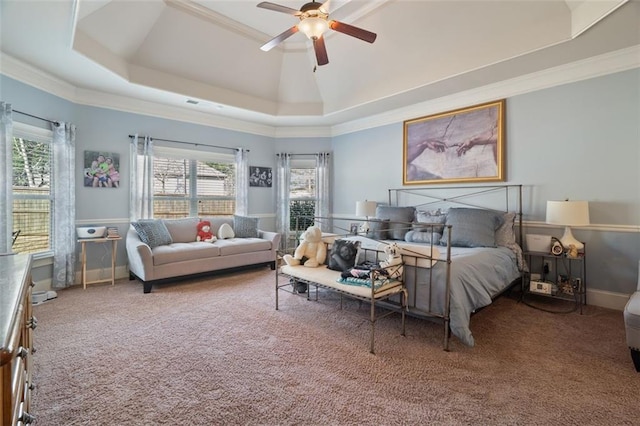 carpeted bedroom with ceiling fan, ornamental molding, and a tray ceiling