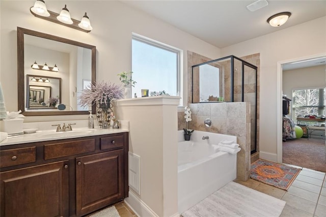 bathroom featuring tile patterned flooring, vanity, and shower with separate bathtub