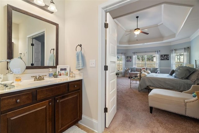 bathroom featuring vanity, a tray ceiling, crown molding, and ceiling fan