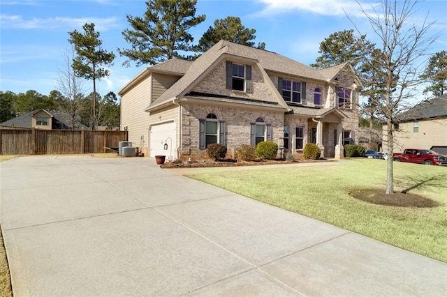 view of front of home featuring cooling unit, a garage, and a front lawn