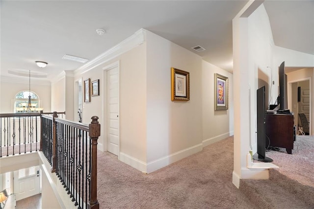 corridor featuring light carpet, crown molding, and a chandelier