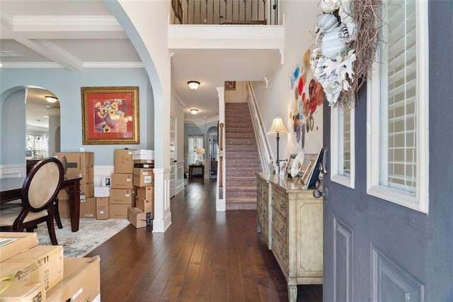 foyer with beamed ceiling, ornamental molding, coffered ceiling, and dark wood-type flooring