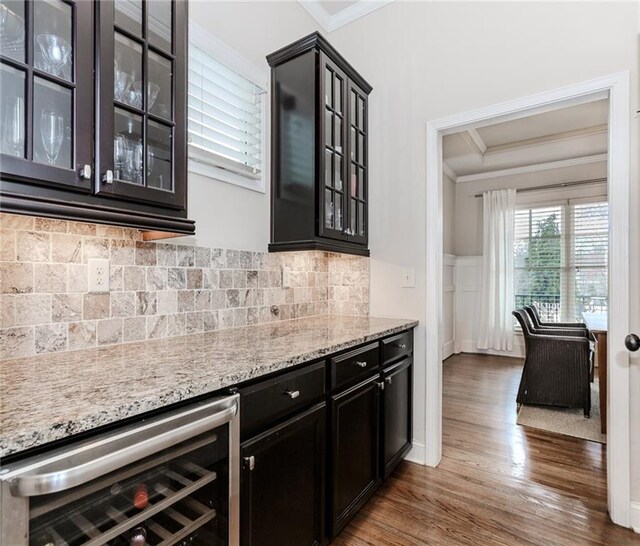 bar area with ornamental molding, wine cooler, dark wood-style floors, and tasteful backsplash