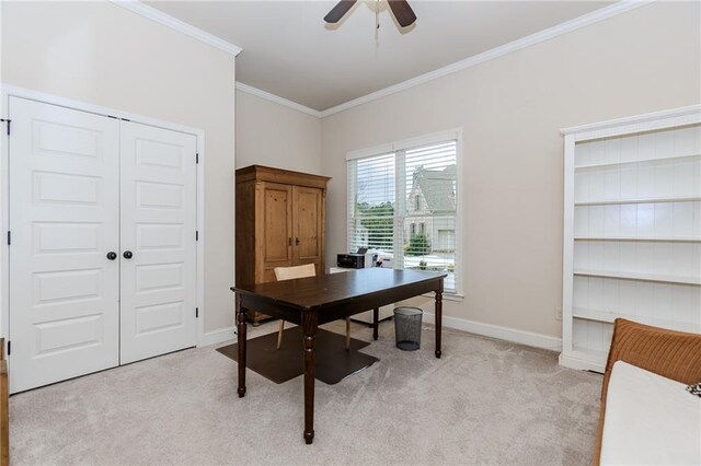 home office with light colored carpet, ornamental molding, a ceiling fan, and baseboards