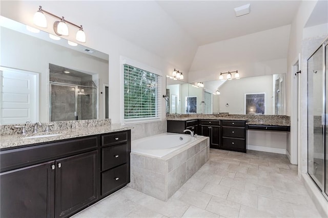 bathroom featuring a shower stall, a bath, two vanities, lofted ceiling, and tile patterned flooring