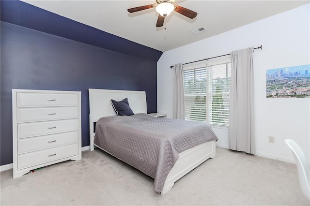 bedroom with light colored carpet, baseboards, and a ceiling fan