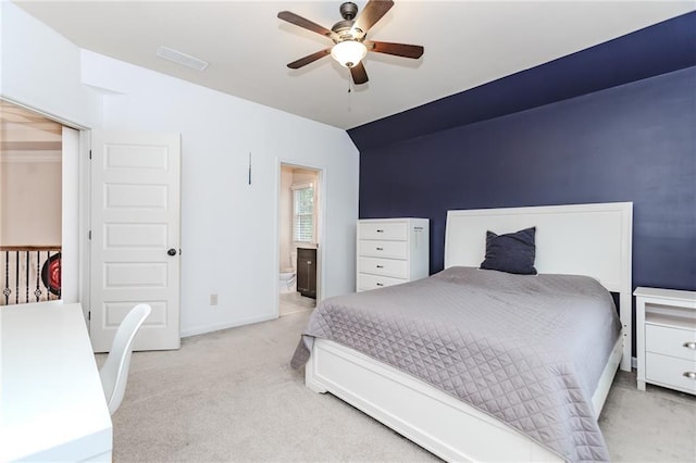 carpeted bedroom with connected bathroom, a ceiling fan, baseboards, and vaulted ceiling