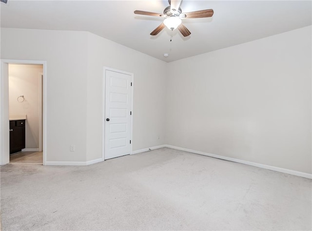unfurnished bedroom featuring light carpet, baseboards, connected bathroom, and ceiling fan
