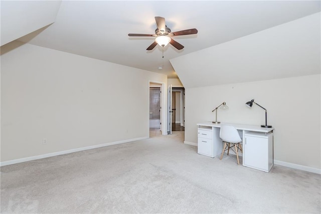 unfurnished office with ceiling fan, light carpet, baseboards, and vaulted ceiling