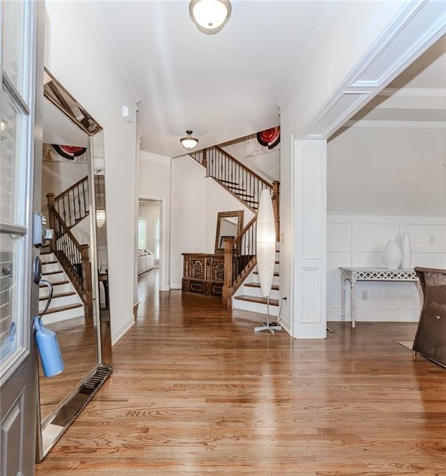 foyer with stairway, light wood-style flooring, and ornamental molding