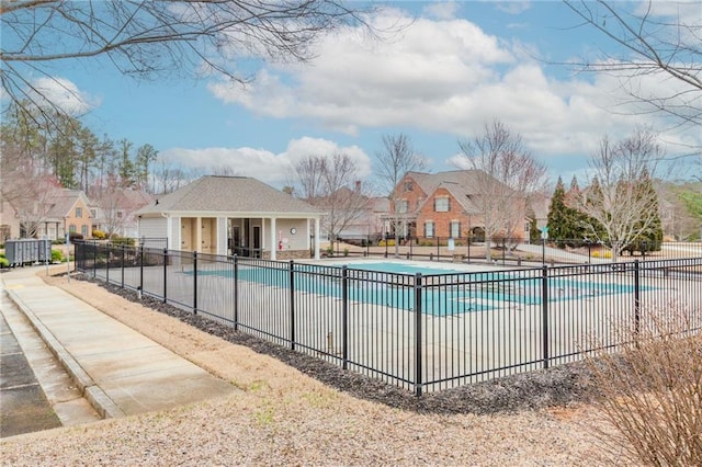 community pool featuring fence and a residential view