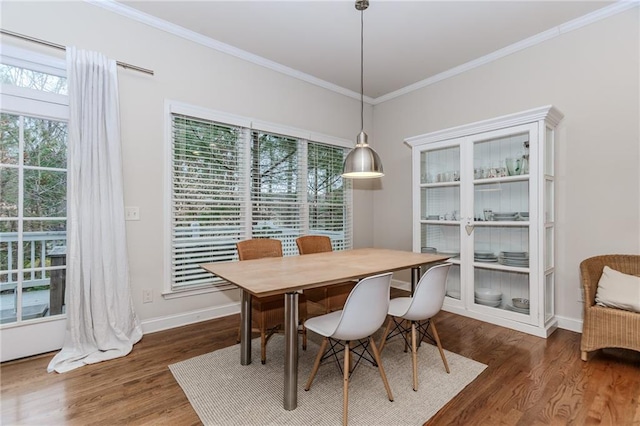 dining room with ornamental molding, wood finished floors, and baseboards