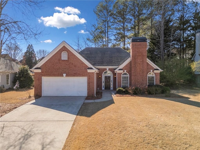 view of front facade featuring roof with shingles, driveway, a chimney, a garage, and brick siding