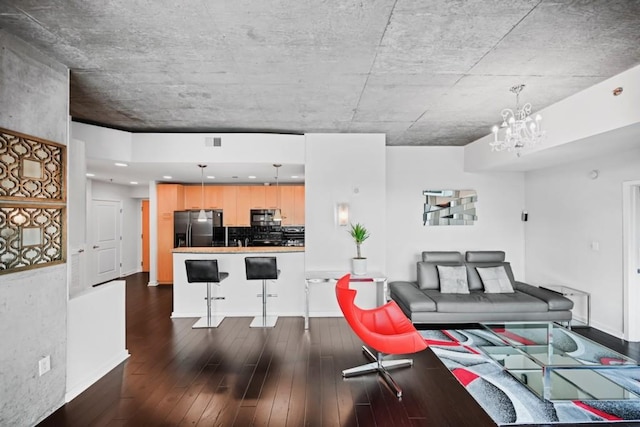 living room with a notable chandelier and dark hardwood / wood-style flooring