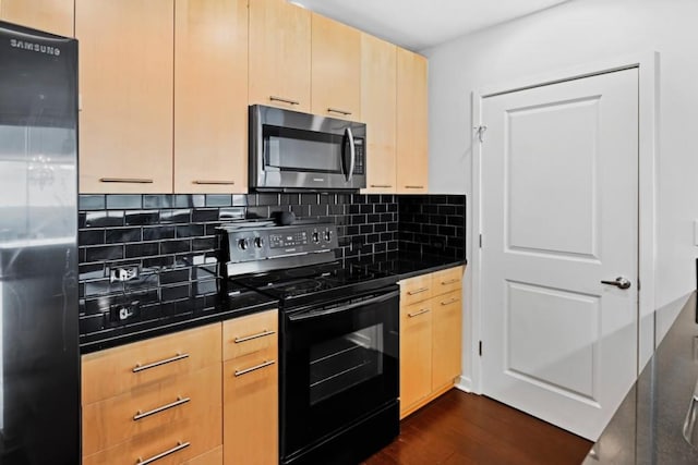 kitchen featuring light brown cabinetry, stainless steel appliances, backsplash, dark countertops, and dark wood-type flooring
