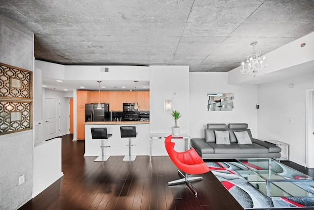 living area with an inviting chandelier, visible vents, dark wood-style floors, and baseboards