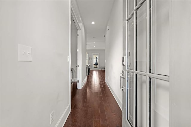 hallway with dark wood-type flooring, recessed lighting, and baseboards