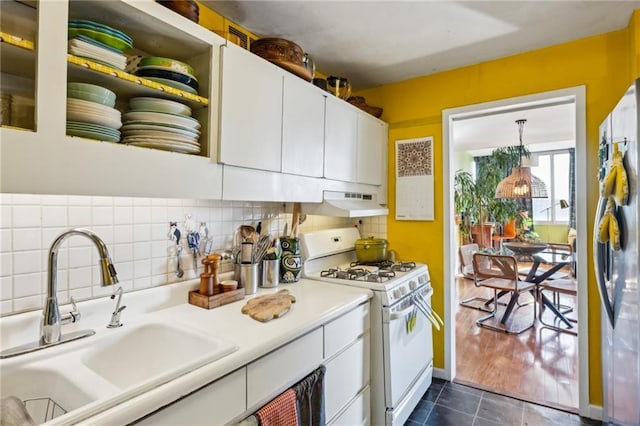 kitchen with sink, white cabinetry, stainless steel fridge, white gas range oven, and decorative backsplash