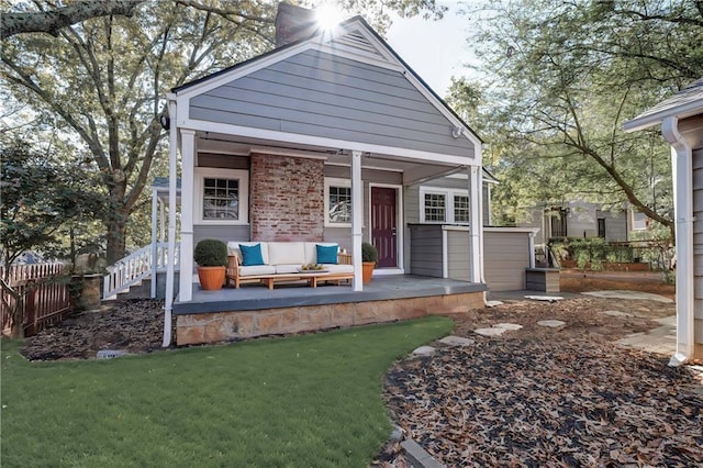 exterior space with brick siding, a chimney, a lawn, fence, and a jacuzzi