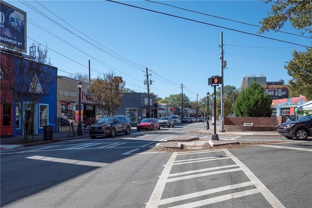 view of street featuring sidewalks, traffic lights, street lights, and curbs